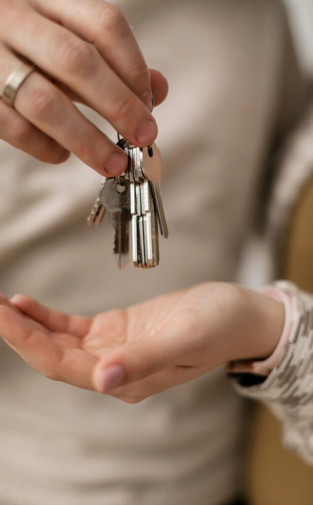 pexels photo 7641904 7641904 A close-up photograph of hands exchanging keys, symbolizing new home ownership.